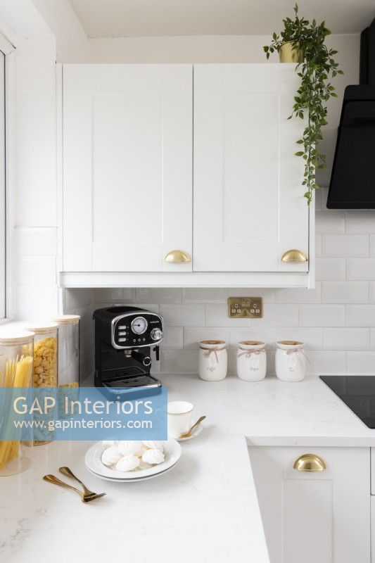 Detail of a corner in a styled white modern kitchen with worktop and cupboard