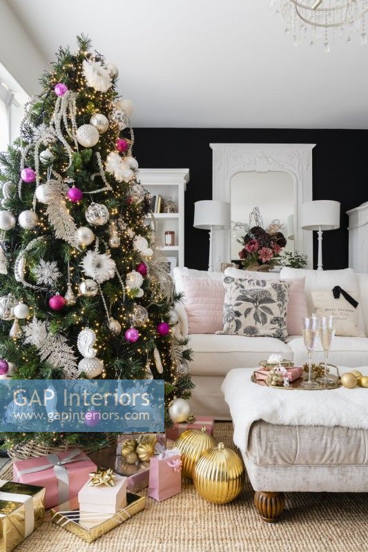 Modern black and white living room with decorated Christmas tree and white sofa