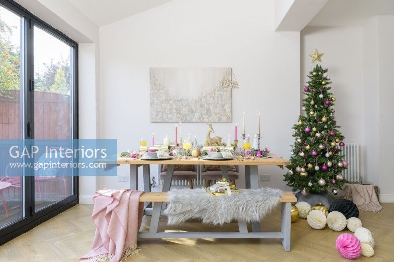 Dining table and bench in a modern kitchen diner with Christmas tree