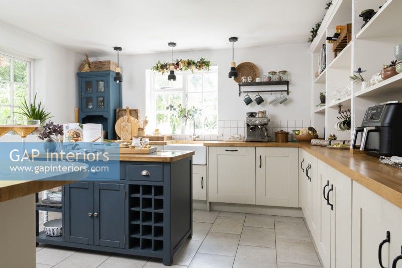 Blue and cream Shaker style country white kitchen with grey tiled floor