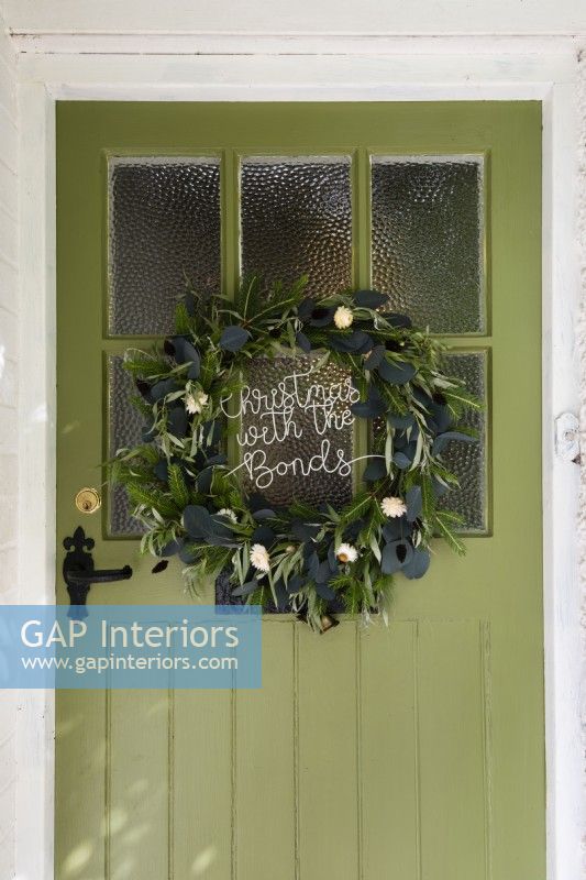Christmas wreath on a green country cottage glazed front door