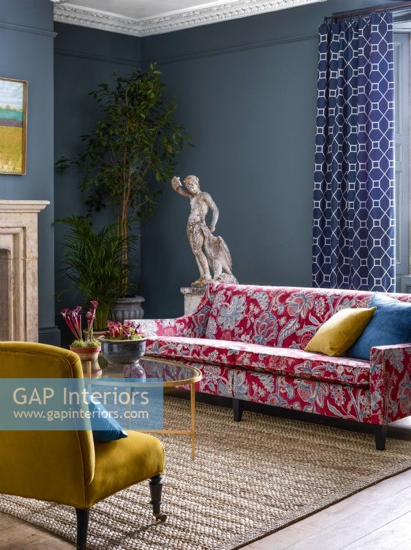 Classic living room with red patterned sofa and blue walls