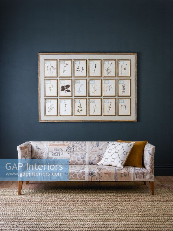 Classic patterned sofa against blue wall with picture