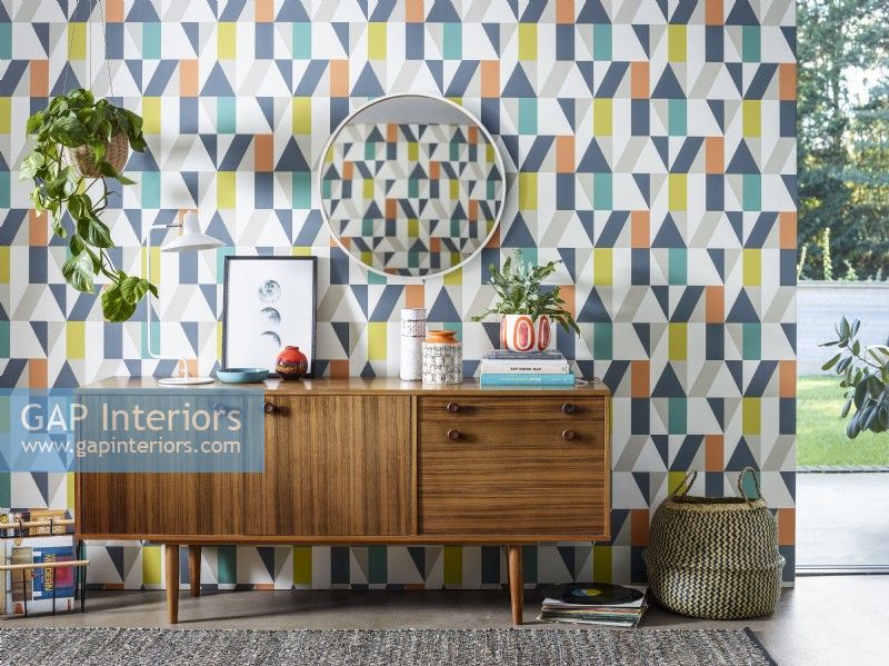Modern retro sideboard in from of patterned wallpaper