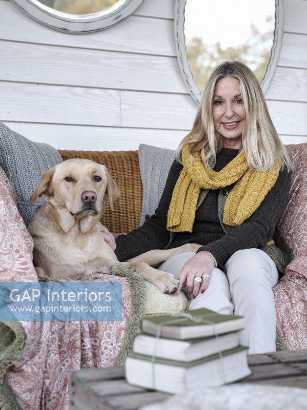 Portrait of homeowner Tracey Gill on the porch with pet dog 