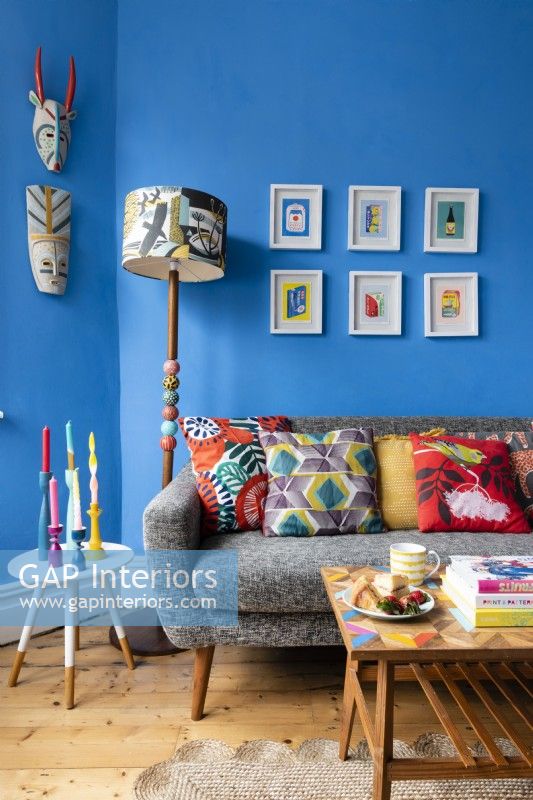 Gray sofa with cushions in a colourful blue living room
