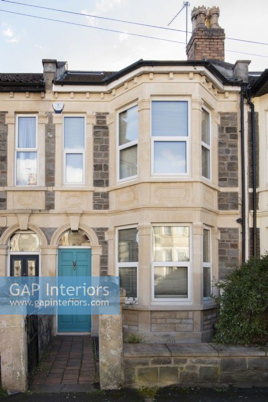 Victorian terrace two storey stone house with a blue/green front door