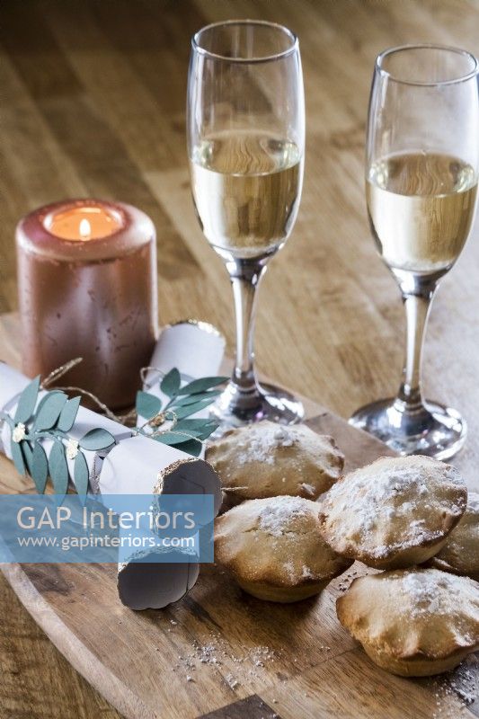 Detail of mince pies, champagne and Christmas crackers