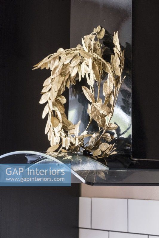 Golden wreath against black extractor fan - Kitchen detail