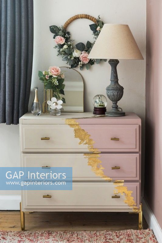 Detail of decorated chest of drawers in feminine bedroom