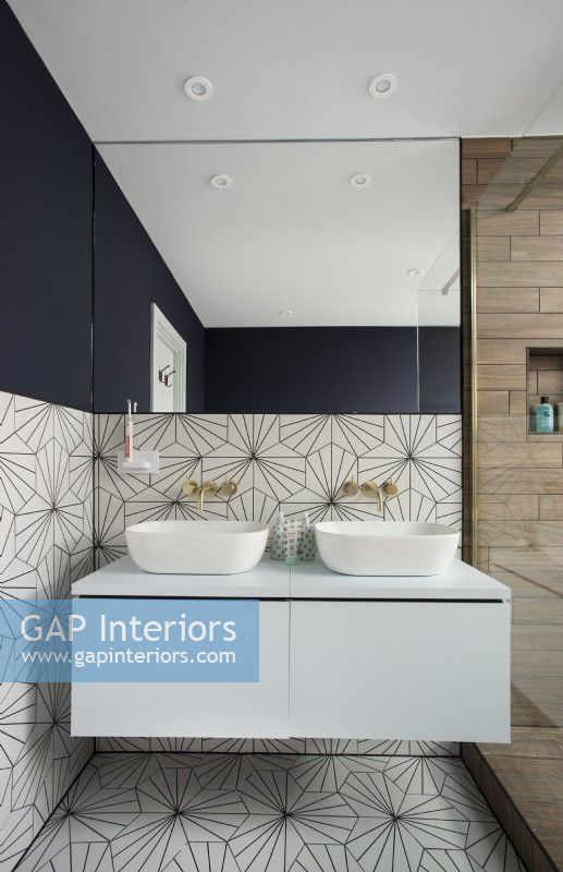Patterned walls and flooring in modern bathroom with double sinks