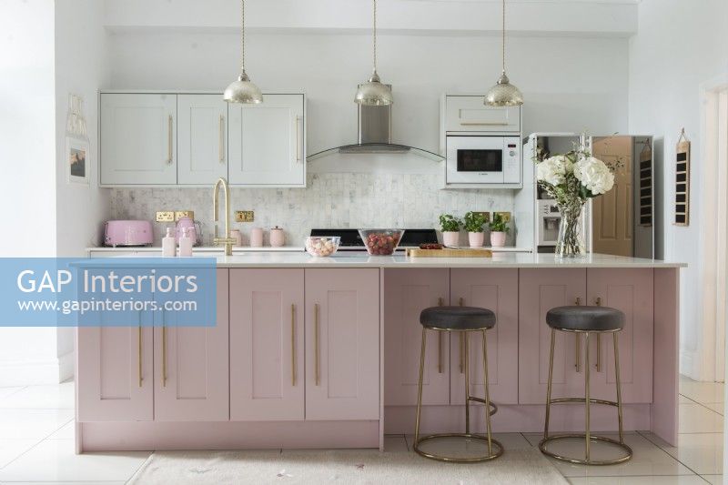 Modern pink and white kitchen with gold handles