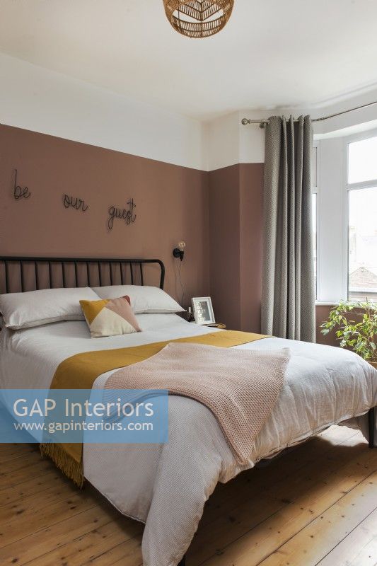 Modern guest room with dusky pink painted walls 