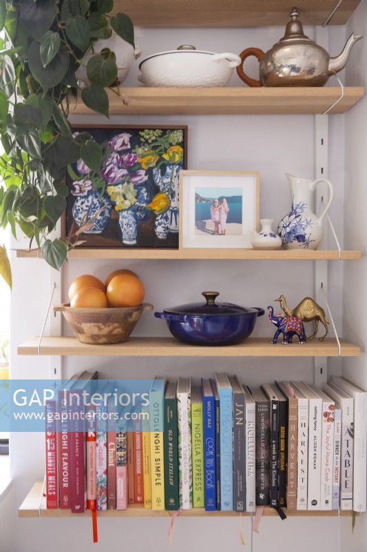 Accessories and cookbooks on kitchen shelves