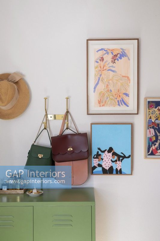 Detail of bedroom with handbags and artwork