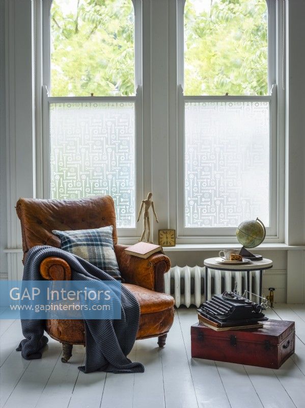 Patterned privacy window film on sash windows in rustic living room