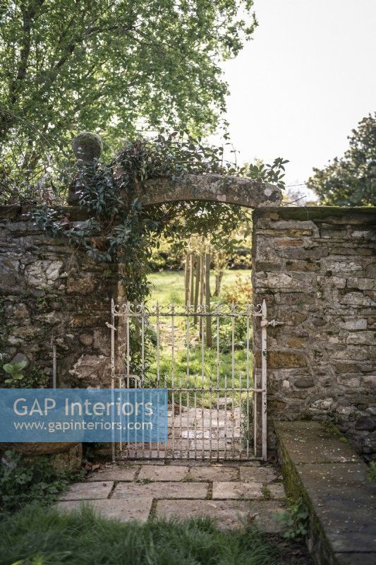 Stone wall and gate in country garden 