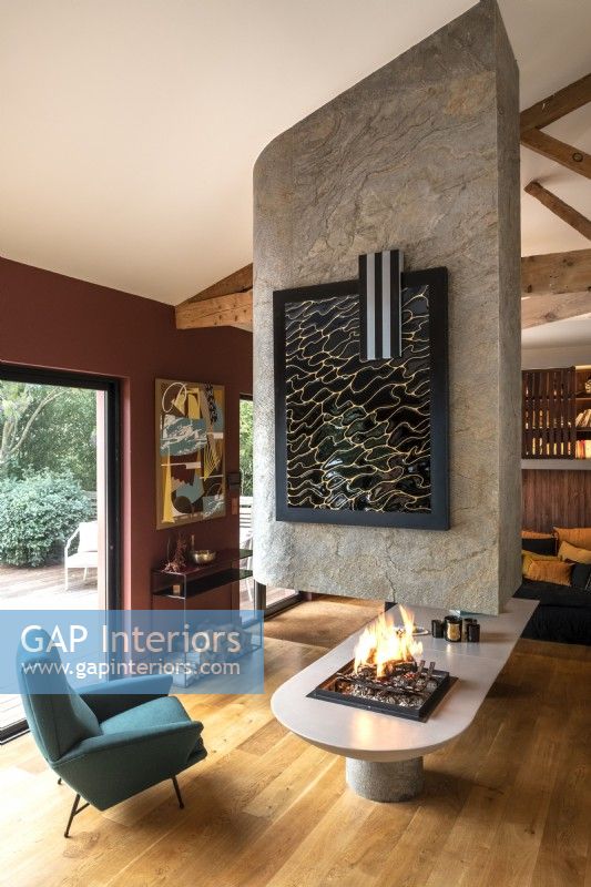 Contemporary lit feature fireplace in centre of living space