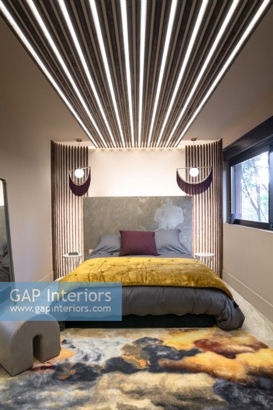 Contemporary bedroom with strips of lighting around and above bed