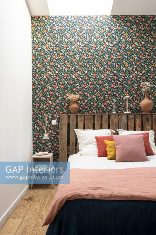 Salvaged wooden pallet used as headboard in eclectic bedroom