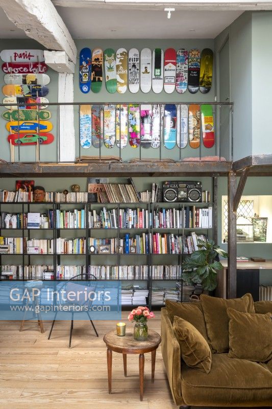 Large bookshelves under mezzanine with skateboard wall display