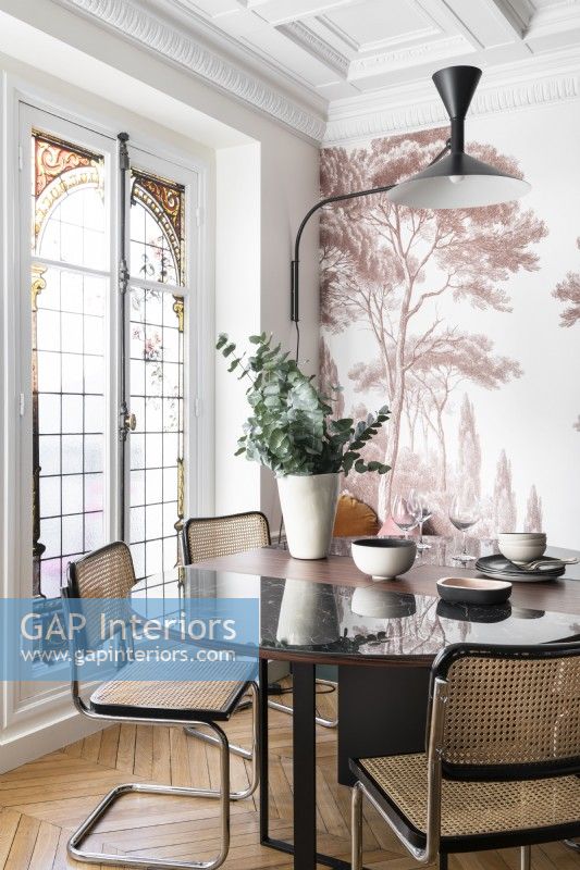 Tree mural on feature wall behind modern dining table