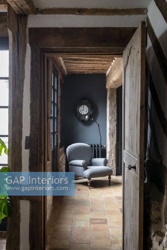 Antique grey chair in country hallway with stone tiled floor