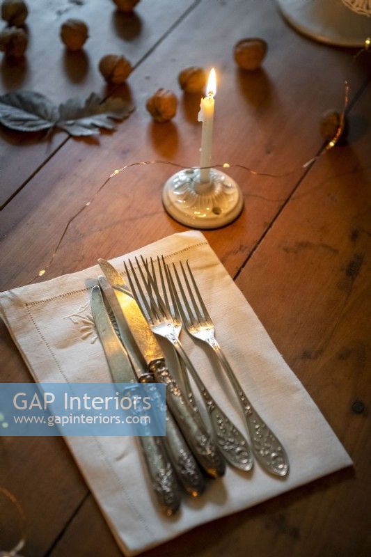 Silverware and napkin on wooden dining table - detail