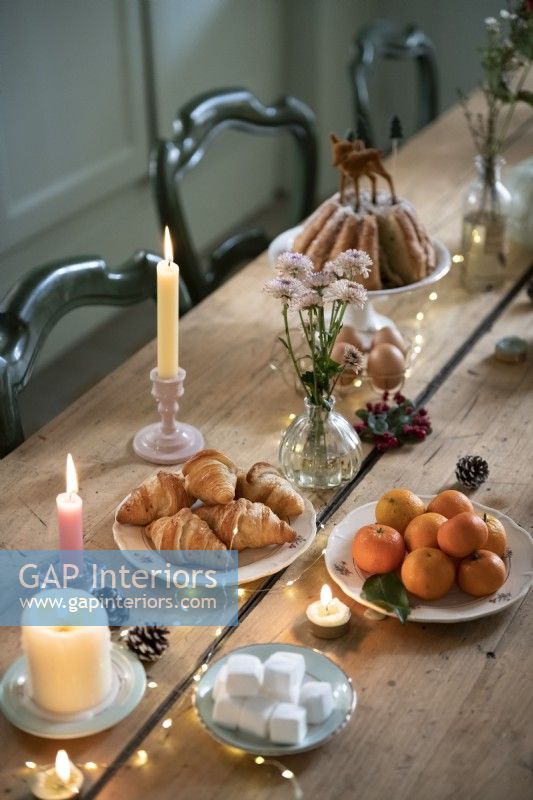 Detail of food and candles on wooden dining table