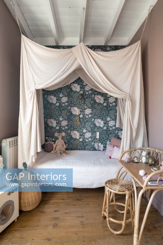 Childrens bed with canopy and floral wallpaper feature wall