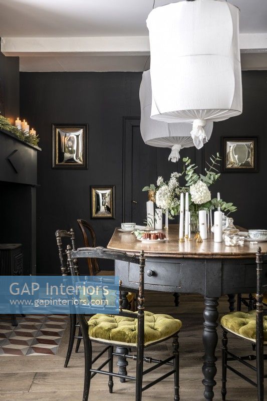 White flowers and lampshades in black painted dining room