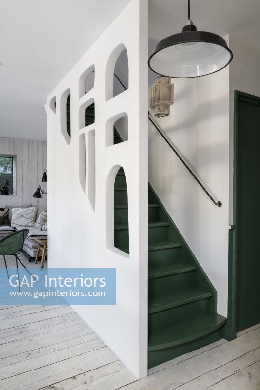 Green and white painted staircase with unusual cut out wall