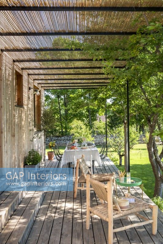 Outdoor seating and dining area on veranda of country house 