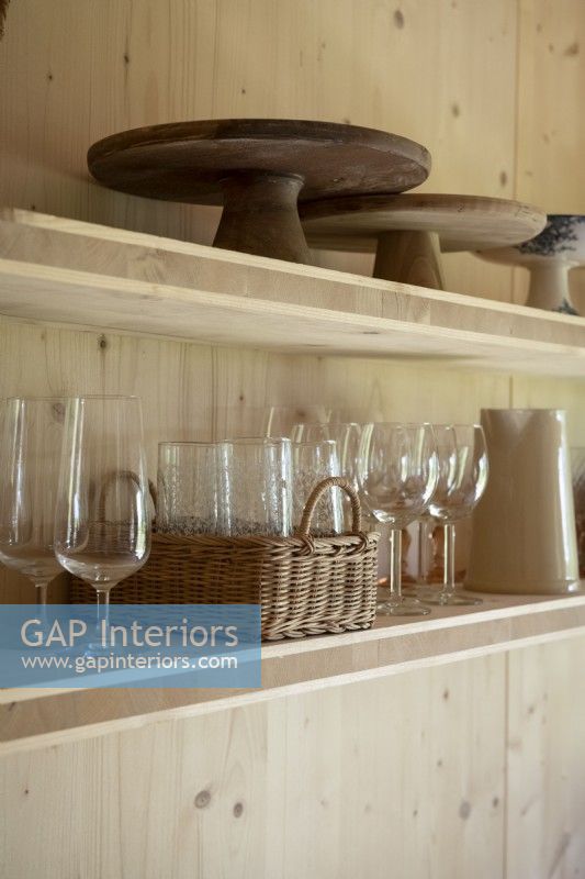 Glassware and kitchen accessories on wooden shelves - detail