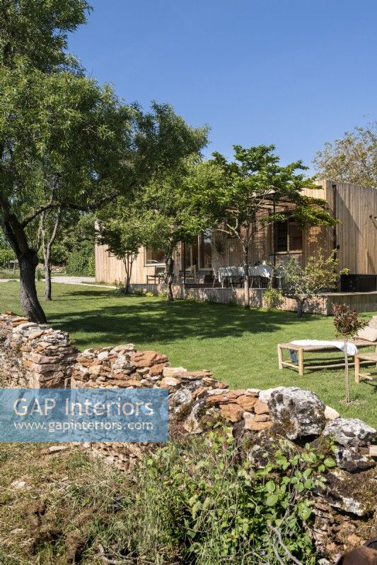 Rustic stone wall leading to country garden with outdoor living spaces