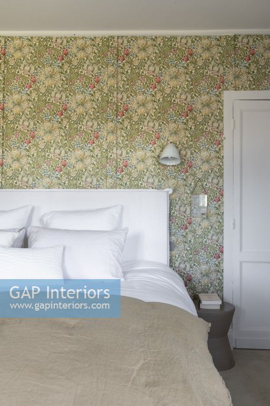 Floral wallpapered walls in country bedroom