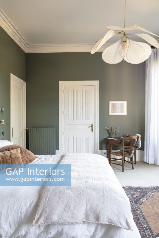 Bedroom with green painted walls and white bedding