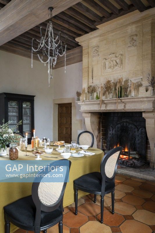 Classic dining room with lit fire in large stone fireplace