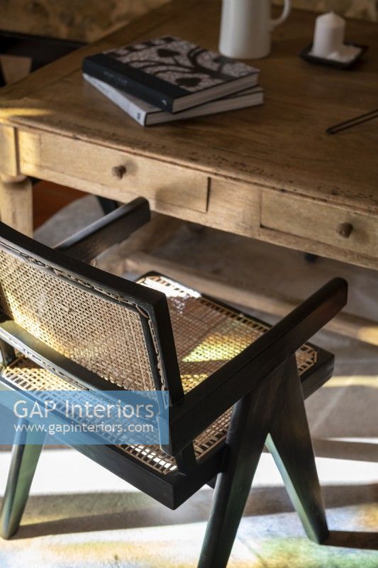 Black wooden and rattan chair next to table