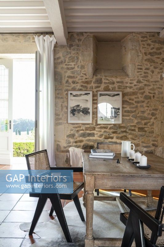 Wooden table and exposed stone walls in country dining area