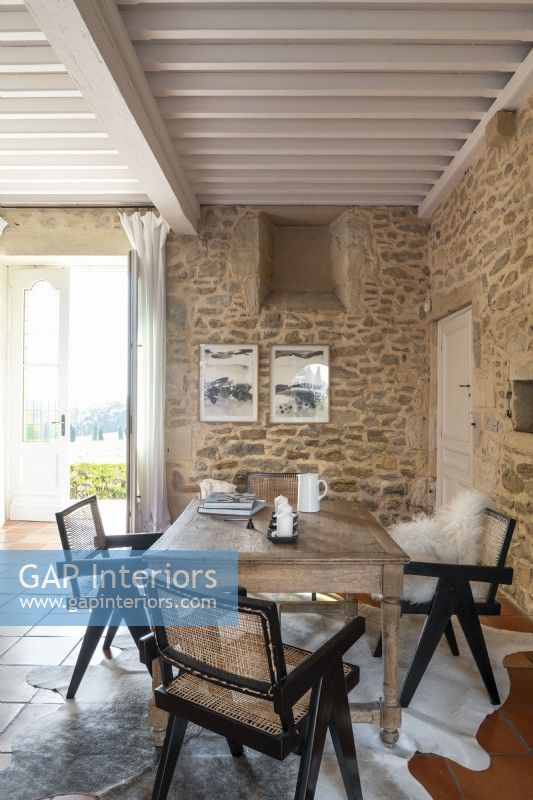 Wooden table in country living room with exposed stone walls