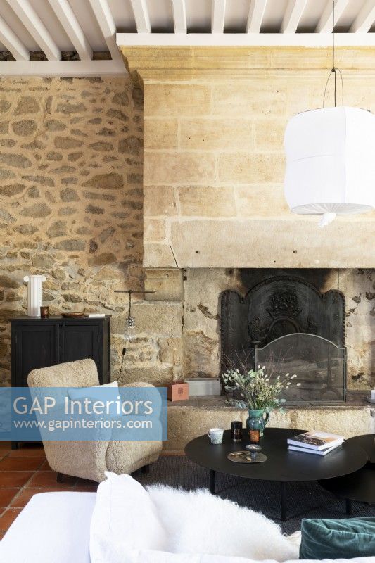 Large fireplace and exposed stone wall in country living room