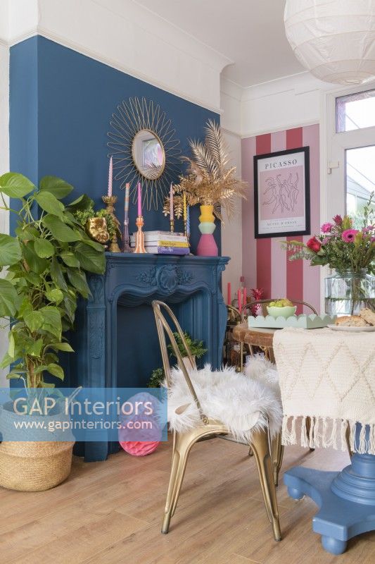 Blue wall and painted fireplace surround in a dining room