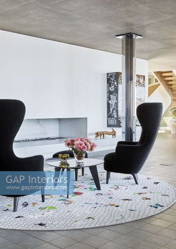 Black armchairs and circular rug in contemporary living room