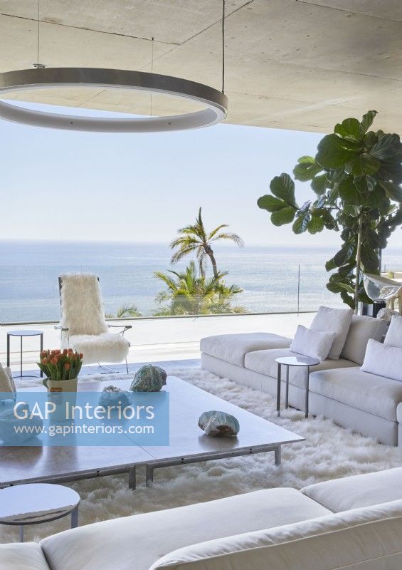 White contemporary living room with picture window and sea view