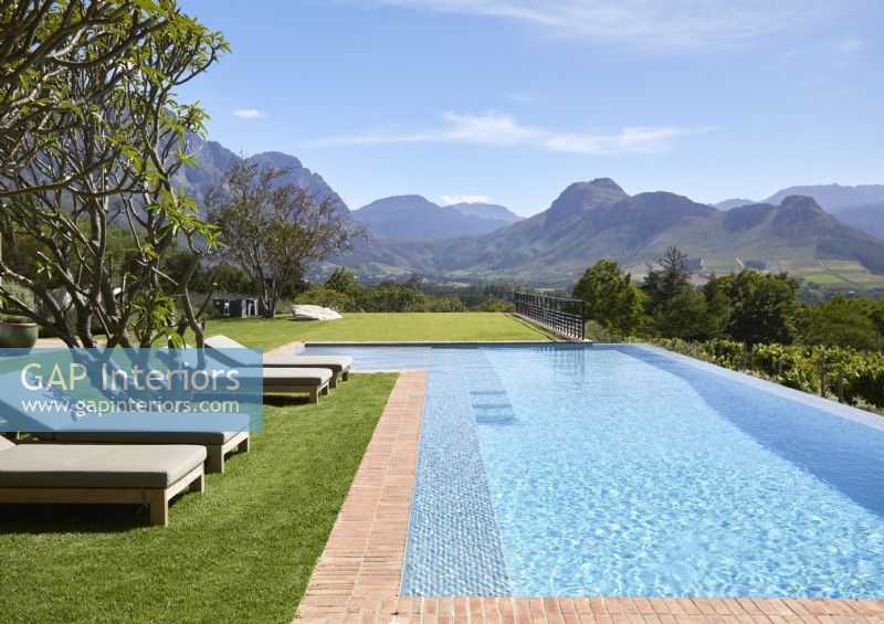 Infinity pool in large garden with views of mountain range beyond