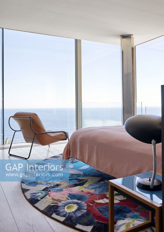 Vibrant circular rug in contemporary bedroom with sea views 