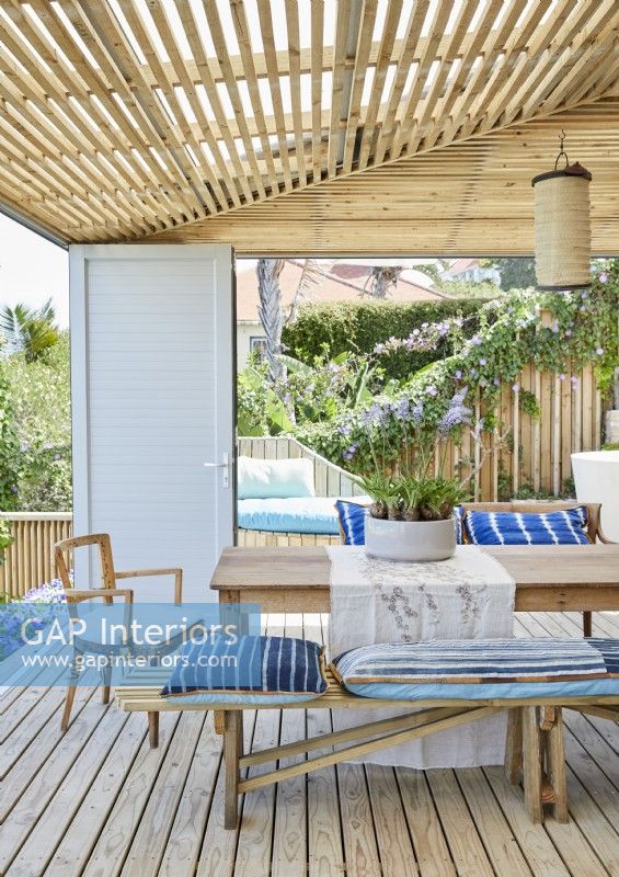 Blue and white cushions on seats around outdoor dining table
