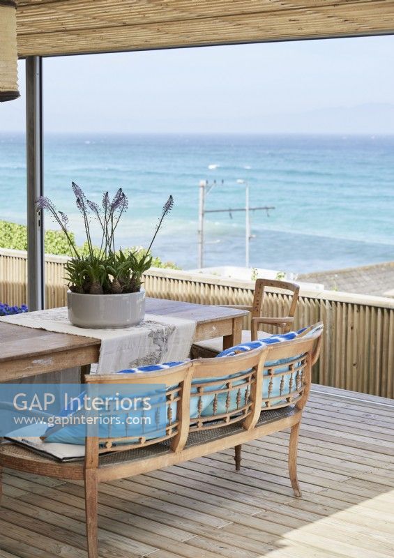 Outdoor dining table and chairs on decked terrace with sea views