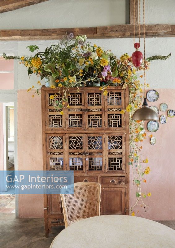 Ornate vintage wooden cabinet with large flower arrangement